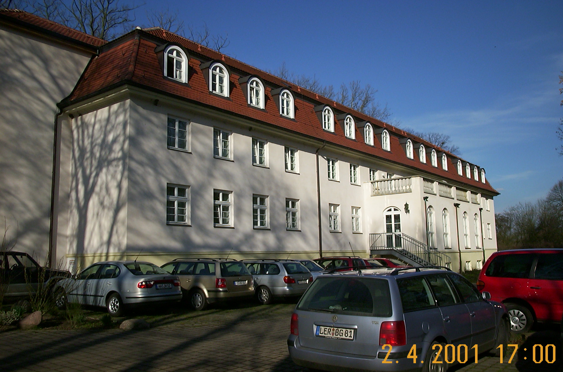 Historische Aufnahme der Längsfassade des Kavaliershauses am Hotel Schloss Storkau von 2001 mit Mansarddach, Bogengauben und parkenden Autos