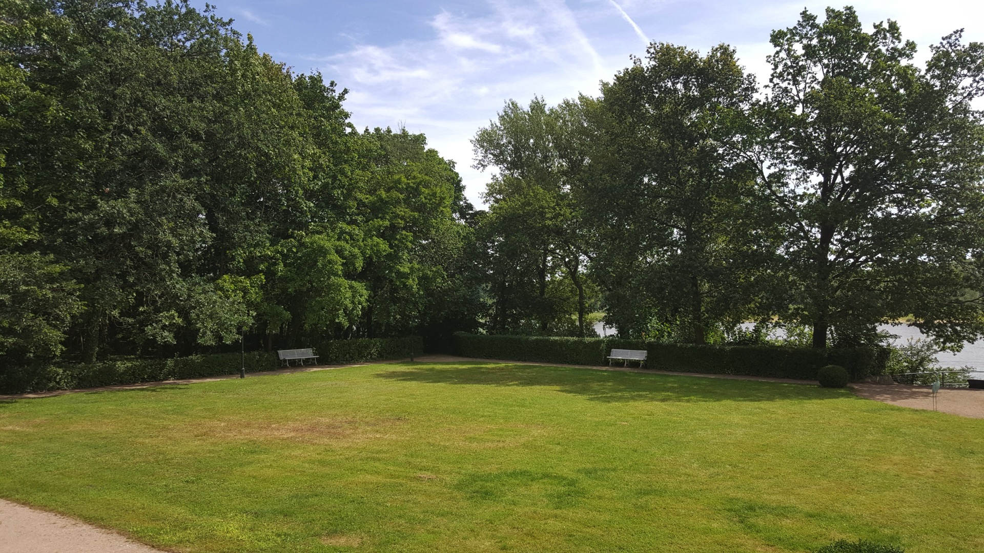 Parkrasen mit Elbblick Weite Rasenfläche im Schlosspark des Hotel Schloss Storkau mit geschnittenen Hecken, weißen Parkbänken und Blick zur Elbe